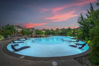 A round swimming pool surrounded by lounge chairs.